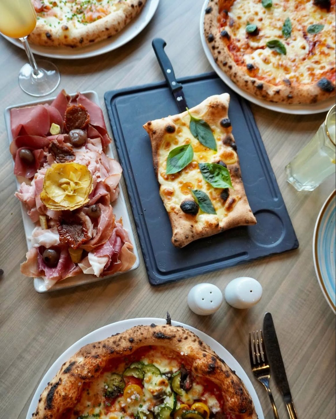 Table avec pizzas et antipasti